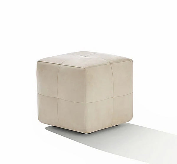 A cube-shaped ottoman upholstered in light beige leather with a tufted top, shown on a clean white background with a soft shadow.