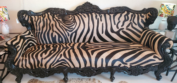 antique vintage sofa with zebra hide fabric for upholstery and a black lacquer frame with carvings
